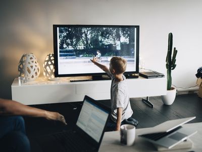 Child kneeling while touching smart TV