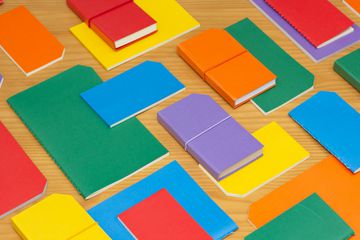 blue, red, yellow, green, orange, and purple papers spread out on a table