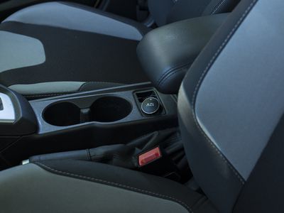 12V socket near a cupholder between two seats.