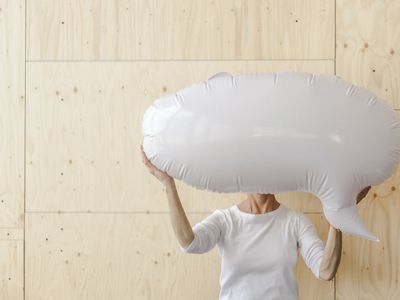 Holding blank inflatable speech balloon in front of face