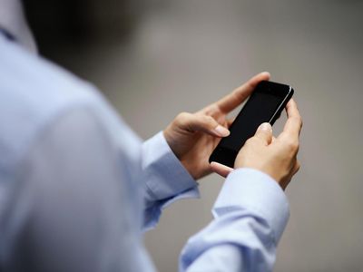 Business man's hands typing on a smart phone