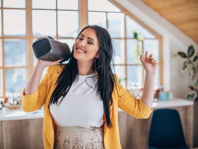 Girl listening to music on a Bluetooth speaker