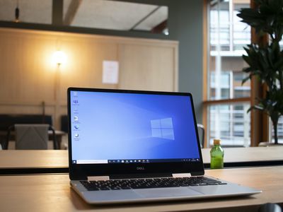 Windows laptop resting on a wooden conference table