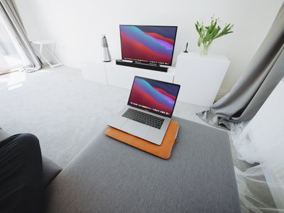 A MacBook computer with the screen mirrored on a nearby television.