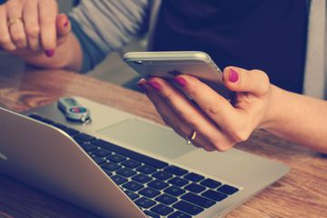 A woman using a PC and smartphone