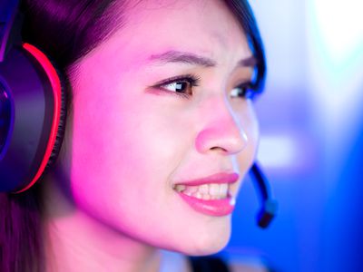 Woman wearing a gaming headset with a mic while playing a video game on an Xbox One.