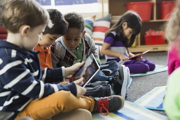 Kids in a classroom using tablets.