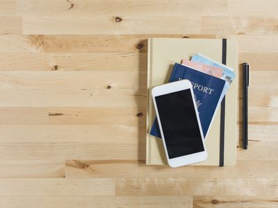 Phone on passport and notebook next to pen