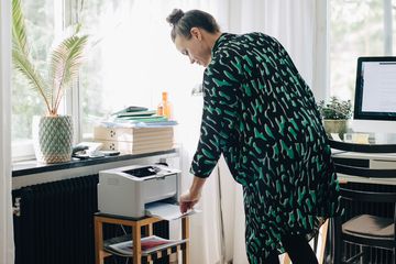 Woman using a desktop printer at home