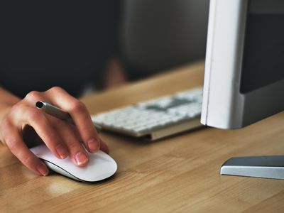 Person holding mouse using desktop computer