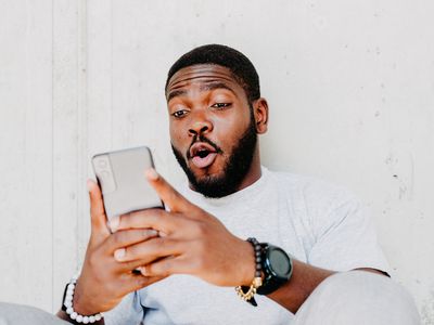 A man looking surprised at what he sees on his smartphone screen