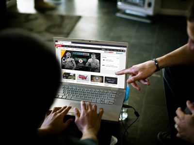 Two fans using a laptop to stream free sports online