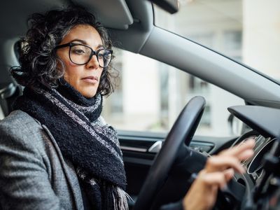 Woman putting on a podcast in a car