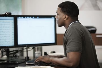 Person using a computer with two monitors