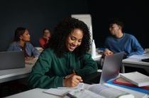 Students attending a lesson, sitting at their desks, in a classroom