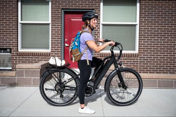 Someone riding the MOD Berlin e-bike on a sidealk. 