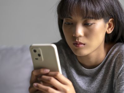 A woman looking seriously at her iPhone smartphone.