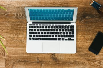 Laptop, smartphone, pencils on wood floor