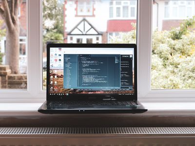 A laptop computer next to a window