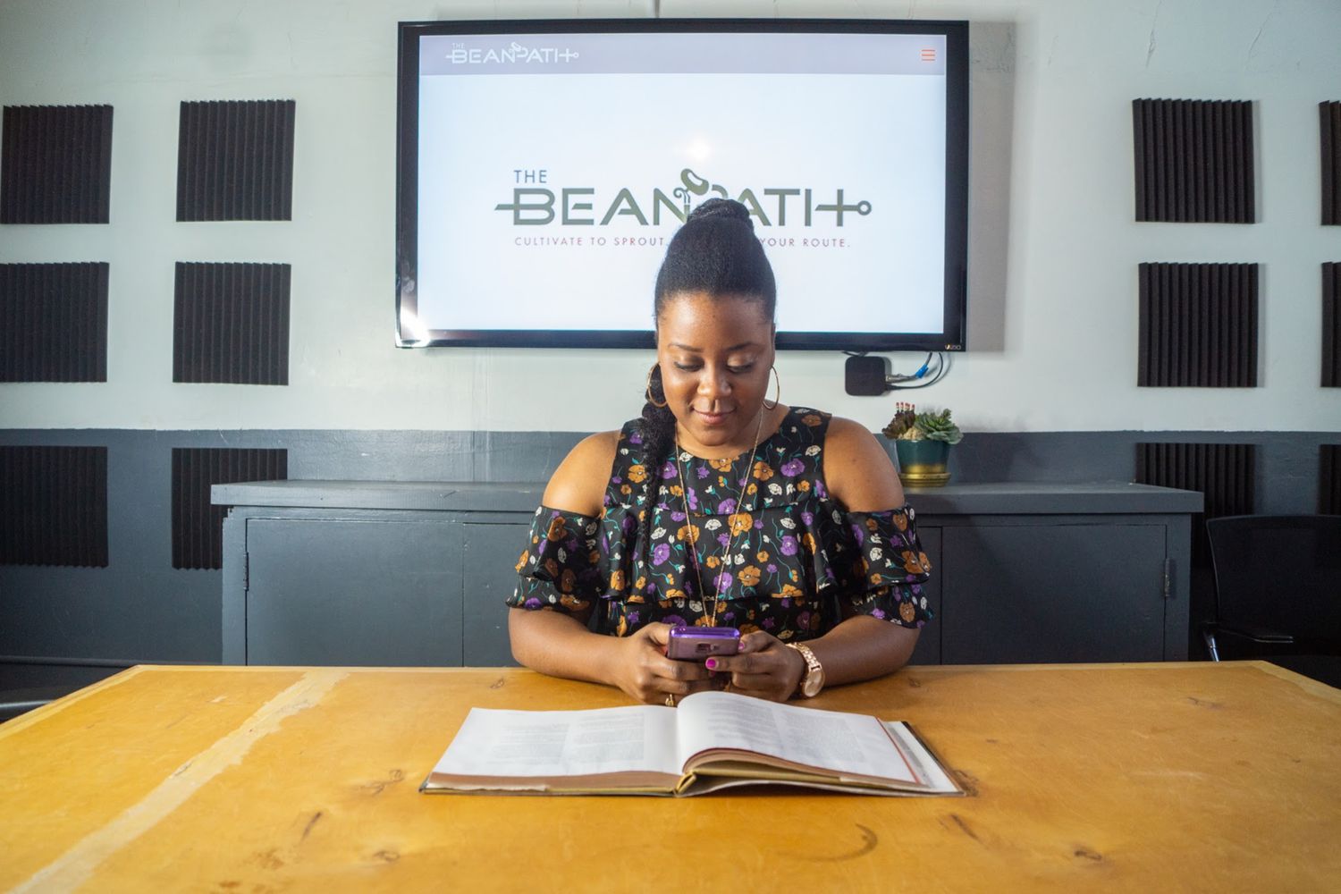 Nashlie Sephus at a desk, reading from her phone