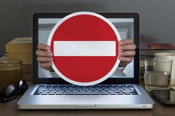 No entry sign appearing out of laptop computer