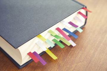 Book with a lot of different colored bookmarks