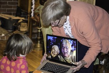 Grandparents talking to grandchild using laptop camera