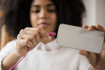 Young girl plugs in a phone.