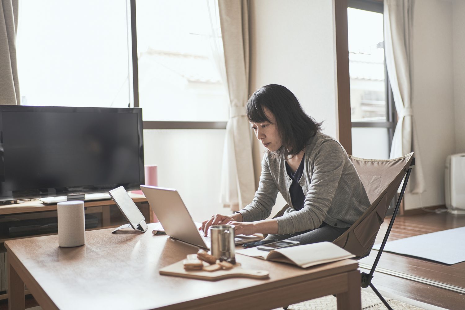 A small business owner working from home at a coffee table.