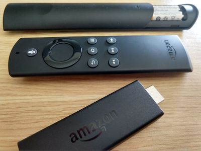 Two Fire Stick remotes and a Fire Stick.