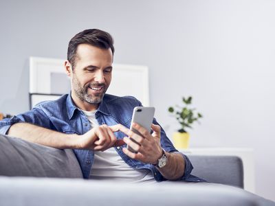 Person sitting on sofa using cellphone.