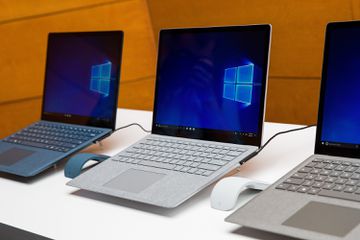 Three Microsoft Surface laptops siting side by side.