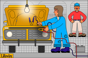 Car mechanic jump starting an automotive battery