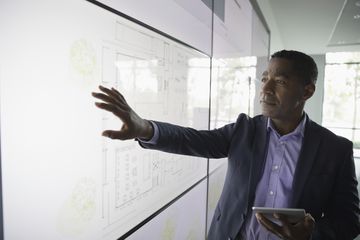 Man standing in front of information displayed from a projector.