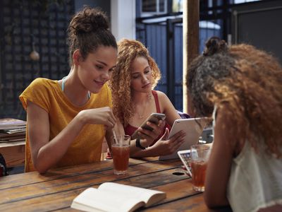 Teenagers using apps on smartphones and tablets.