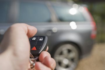 Key fob pointed at a SUV in the background