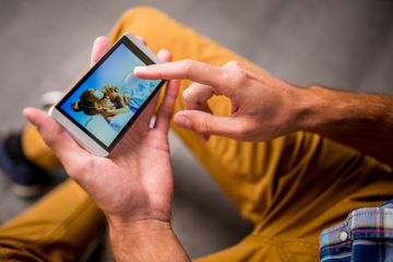 Man swiping through pictures of his family on his smart phone.