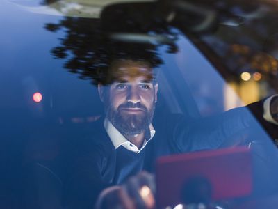 Commuter using a navigation device in car at night