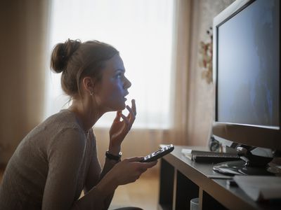 A woman pairs her remote to her smart TV.