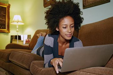 Person using laptop on sofa