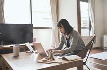 A small business owner working from home at a coffee table.