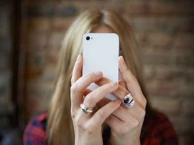 iPhone user holding iPhone over face.