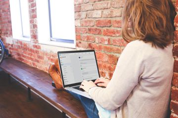 Facebook user sitting on bench searching on Facebook