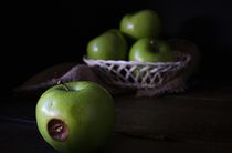 Apples in a basket, one rotting.