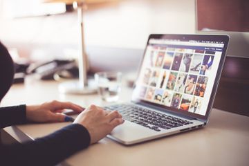 A stock photo of a person browsing the internet on a laptop.