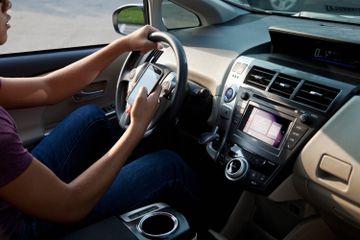 A driver setting up CarPlay SharePlay for their passengers.