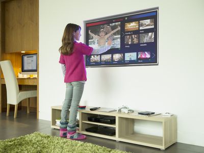 Girl using touch screen television in living room