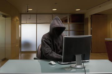 Caucasian man in hoody sitting at office desk