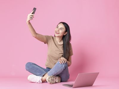 Studio shot of young woman taking selfie 