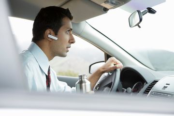 Man in car with bluetooth earpiece